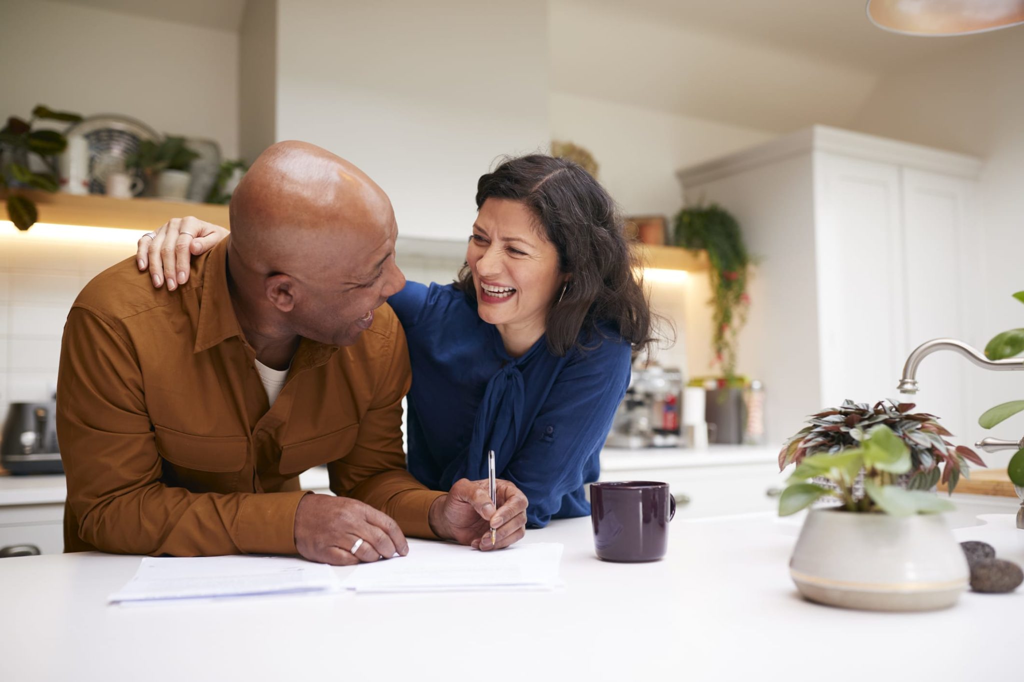GettyImages-1282868177 Smiling Mature Couple Signing Paperwork