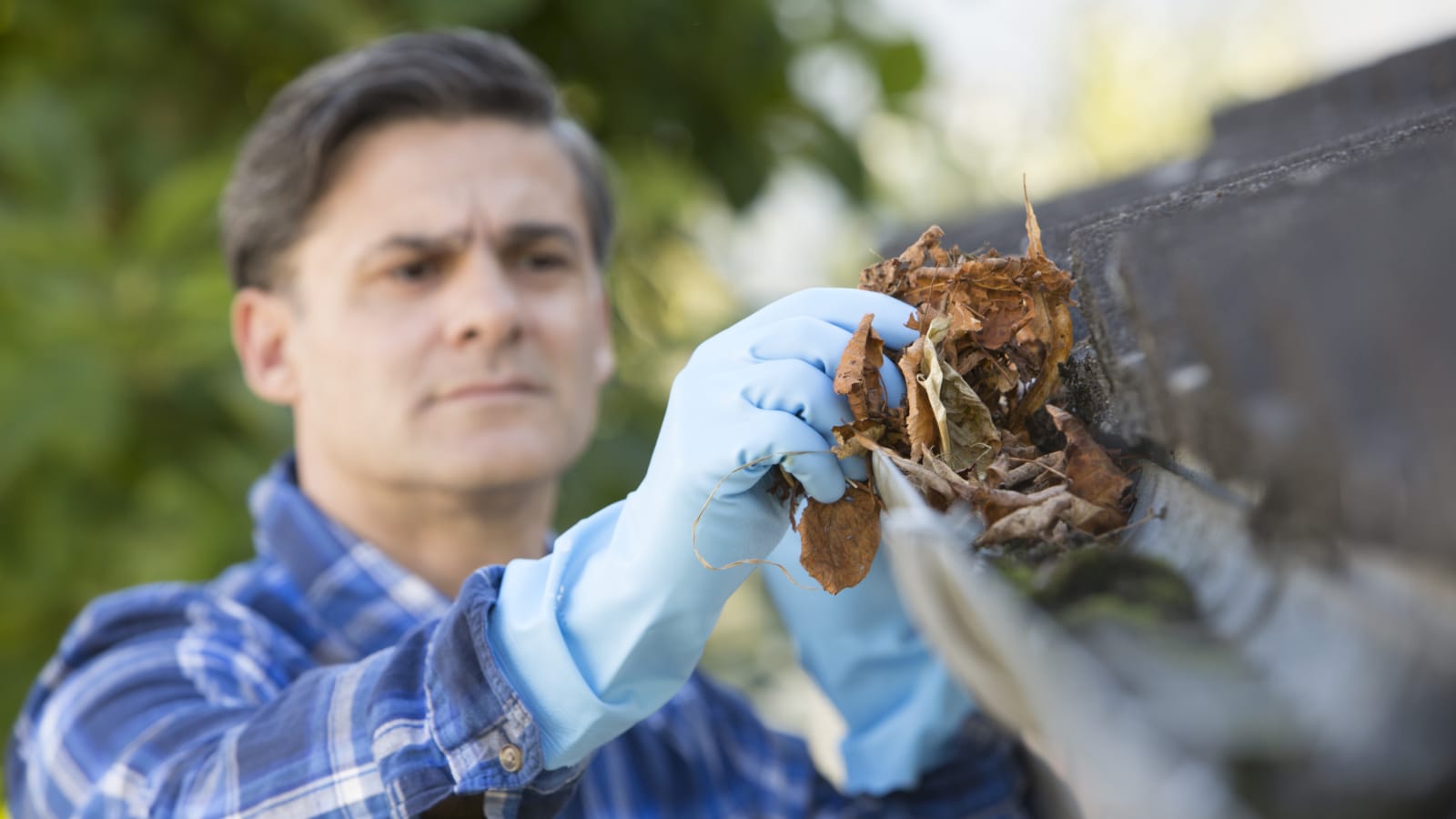 Home Maintenance Checklist: Step by Step Guide to Prepare Your Home for the Fall Man cleaning gutters outside