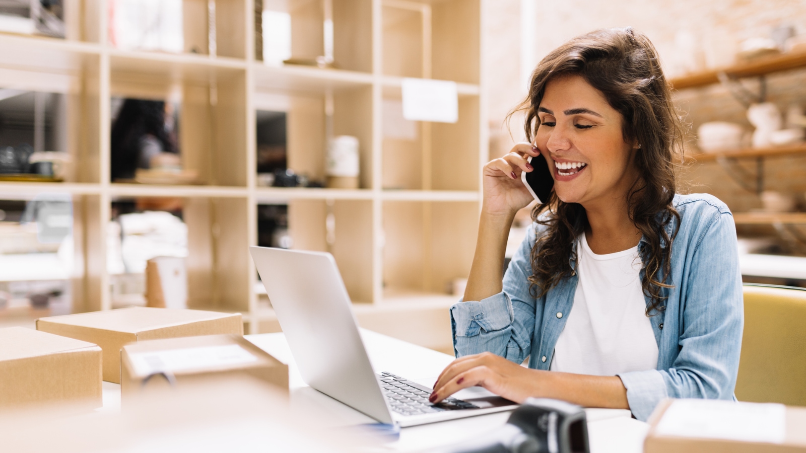 small business saturday businesswoman on a call and working on laptop