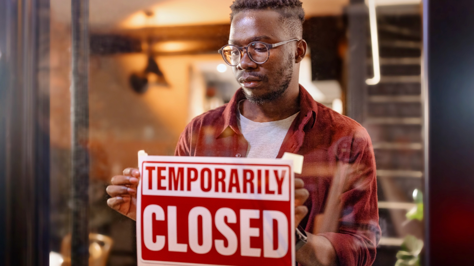 large loss business owner putting up temporarily closed sign